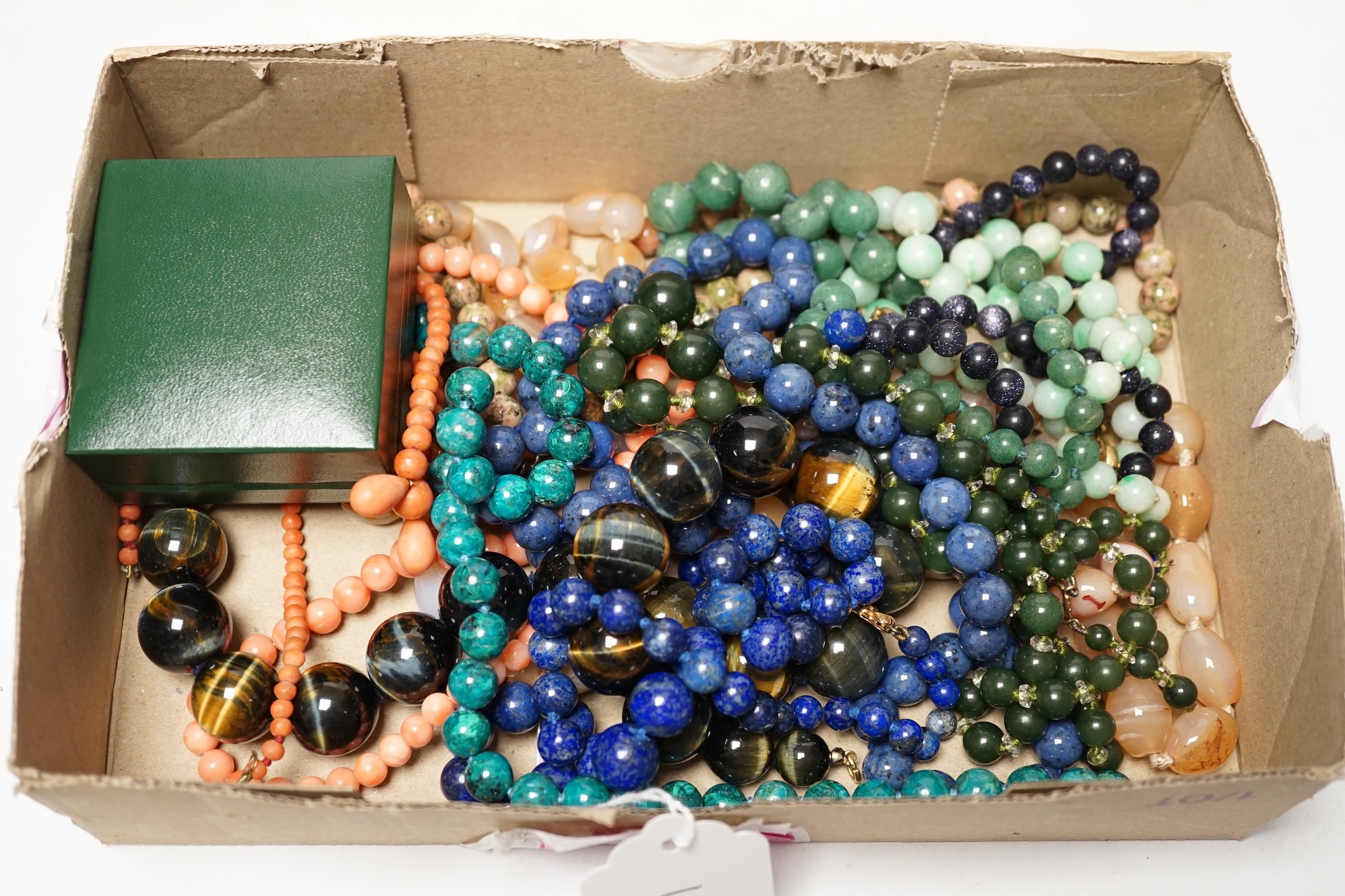 A collection of twelve modern hardstone necklaces, including agate, coral, serpentine and lapis lazuli, 58cm with pair of earrings, together with a pair of malachite drop earrings. Condition - fair